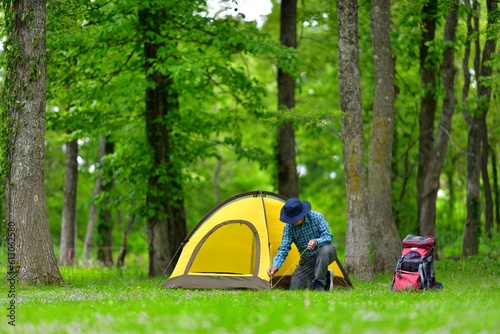 新緑の森でテントキャンプを楽しむ男性