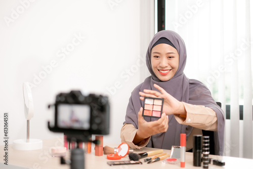 Beauty blogger applying makeup live and selecting professional cosmetics with expertise, showcasing her captivating artistry.