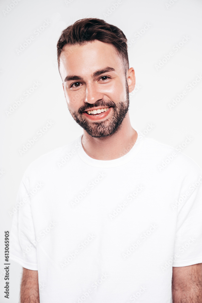 Portrait of handsome smiling stylish hipster lambersexual model. Sexy man dressed in white T-shirt and jeans. Fashion male isolated on white background in studio. Closeup Portrait of handsome smiling stylish hipster lambersexual model. Sexy man dressed in white T-shirt and jeans. Fashion male isolated on white background in studio. Closeup