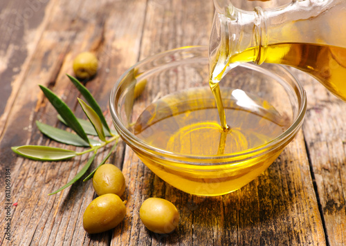 olive oil and leaf on wood background