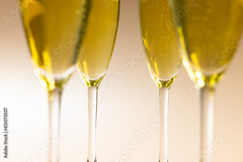 Close-up of champagne flutes with champagne over beige background, copy space