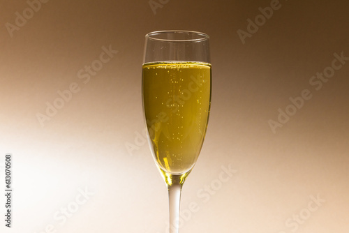 Close-up of champagne in champagne flute isolated against brown background, copy space