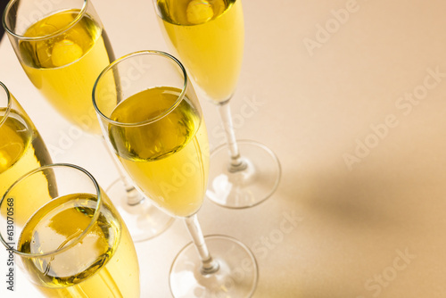 High angle view of champagne flutes with champagne against pink background, copy space