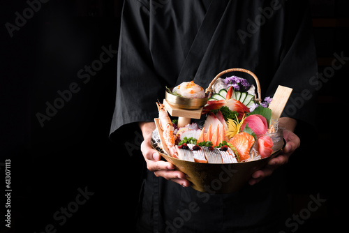 Japanese food, salmon sashimi in an Asian restaurant, Chef hands preparing japanese food, japanese chef making sushi at restaurant photo