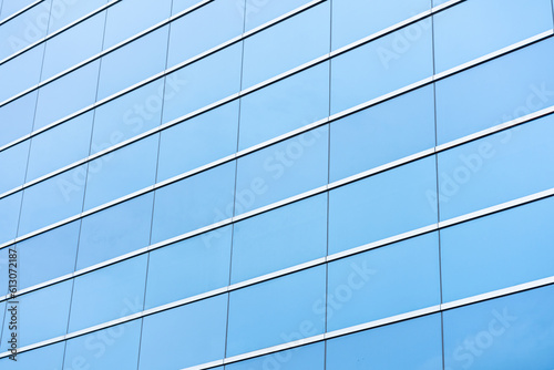 Part of a modern glass building, an aluminum facade that reflects the blue sky.