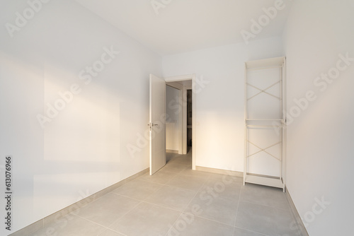 Narrow empty room with a closet and a door overlooking the corridor and other rooms. Concept of the apartment after the delivery of a new building or renovation. Copyspace