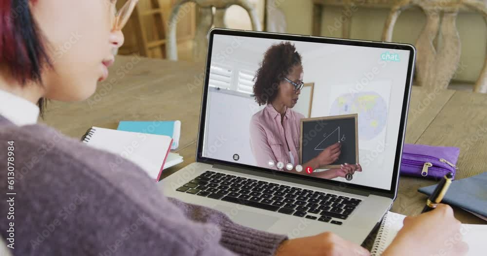 Asian female student using laptop for online lesson with african american teacher on screen Asian female student using laptop for online lesson with african american teacher on screen