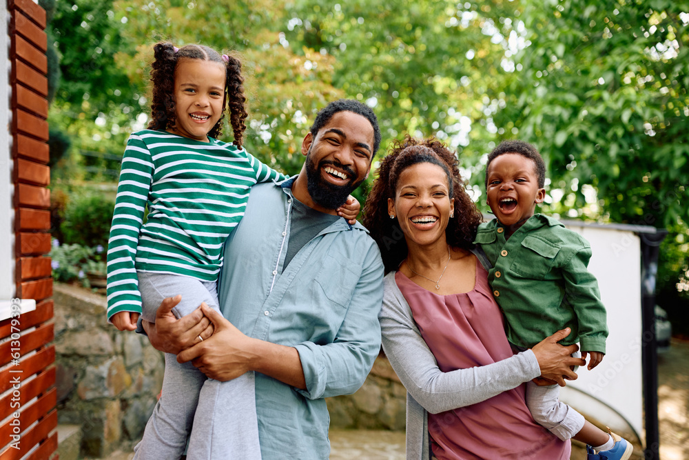 Portrait of cheerful black family in their backyard looking at camera.