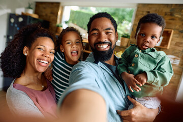 Happy black family has fun while taking selfie at home.