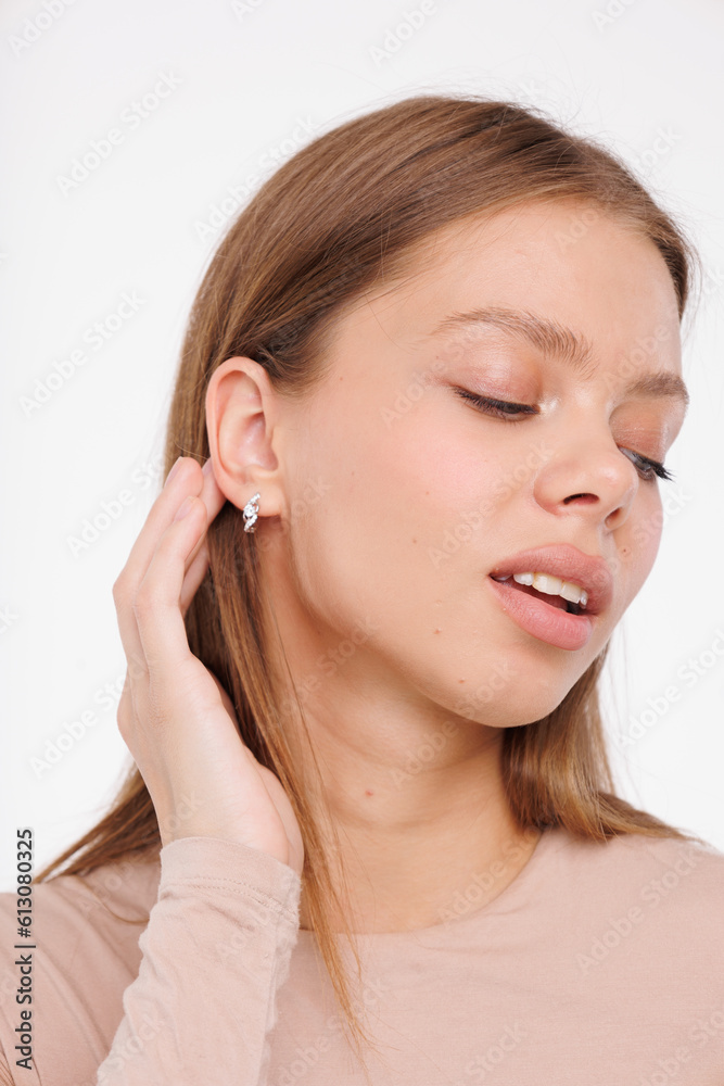 Beautiful young girl with fresh healthy skin. Woman advertise ear-rings. White background. Earrings closeup. Blond european woman with long hair with big lips, pretty smile. Cosmetology, scincare Beautiful young girl with fresh healthy skin. Woman advertise ear-rings. White background. Earrings closeup. Blond european woman with long hair with big lips, pretty smile. Cosmetology, scincare