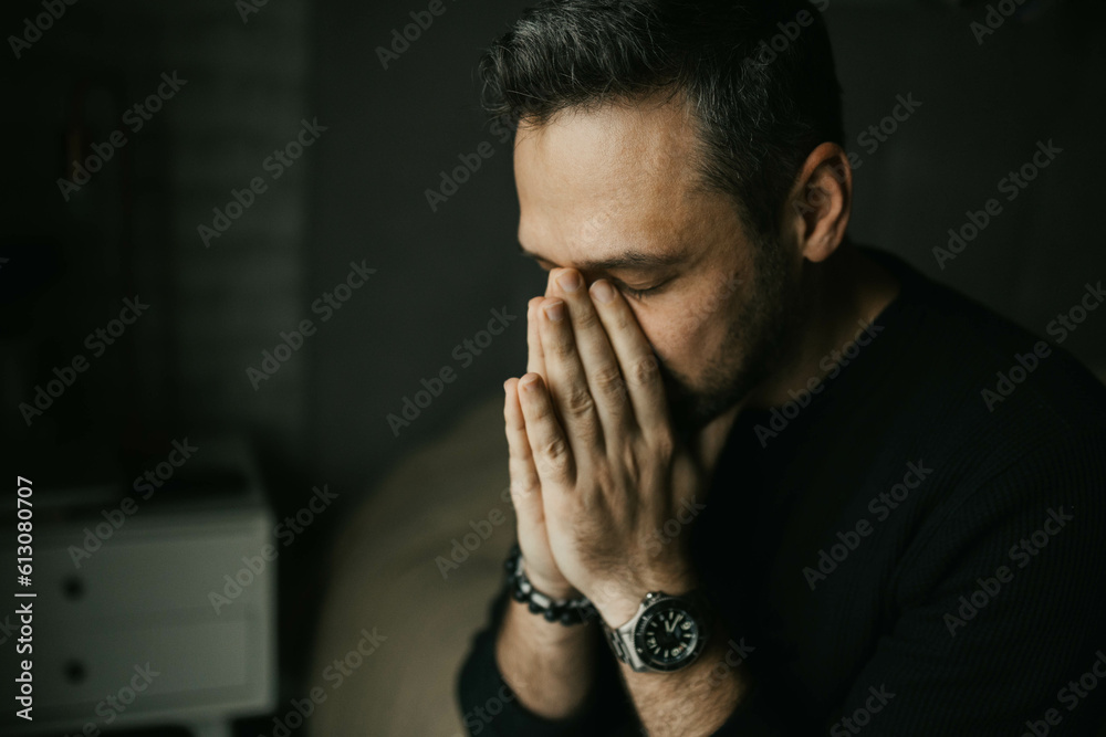 Sad man put his hands to his face sitting on the bed Sad man put his hands to his face sitting on the bed