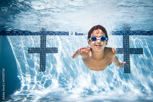 Underwater photograph of boy swimming in goggles.