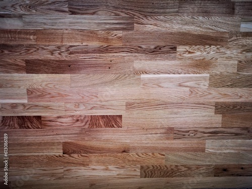 The background for a natural oak parquet board of three strips