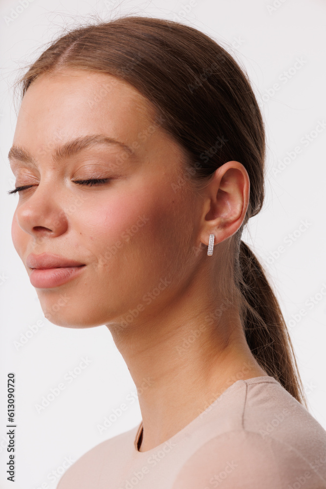 Beautiful young girl with fresh healthy skin. Woman advertise ear-rings. White background. Earrings closeup. Blond european woman with long hair with big lips, pretty smile. Cosmetology, scincare Beautiful young girl with fresh healthy skin. Woman advertise ear-rings. White background. Earrings closeup. Blond european woman with long hair with big lips, pretty smile. Cosmetology, scincare