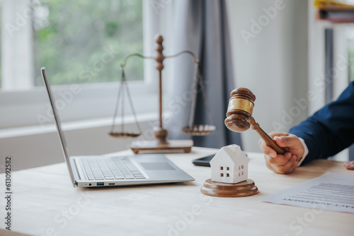 Close-up of a judge\'s hammer small wooden toy house On the table in the courtroom concept of real estate law division of property Land separation and divorce