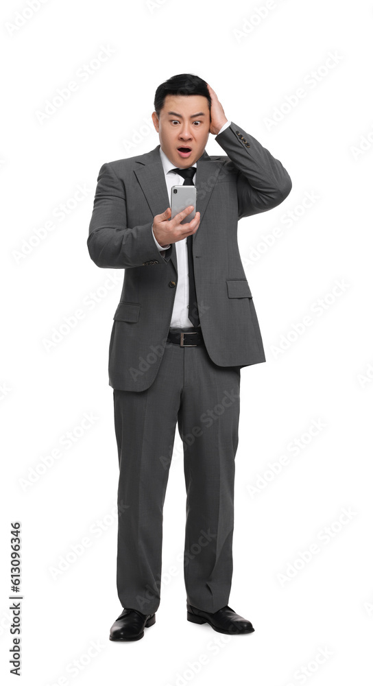 Shocked businessman in suit with smartphone on white background Shocked businessman in suit with smartphone on white background