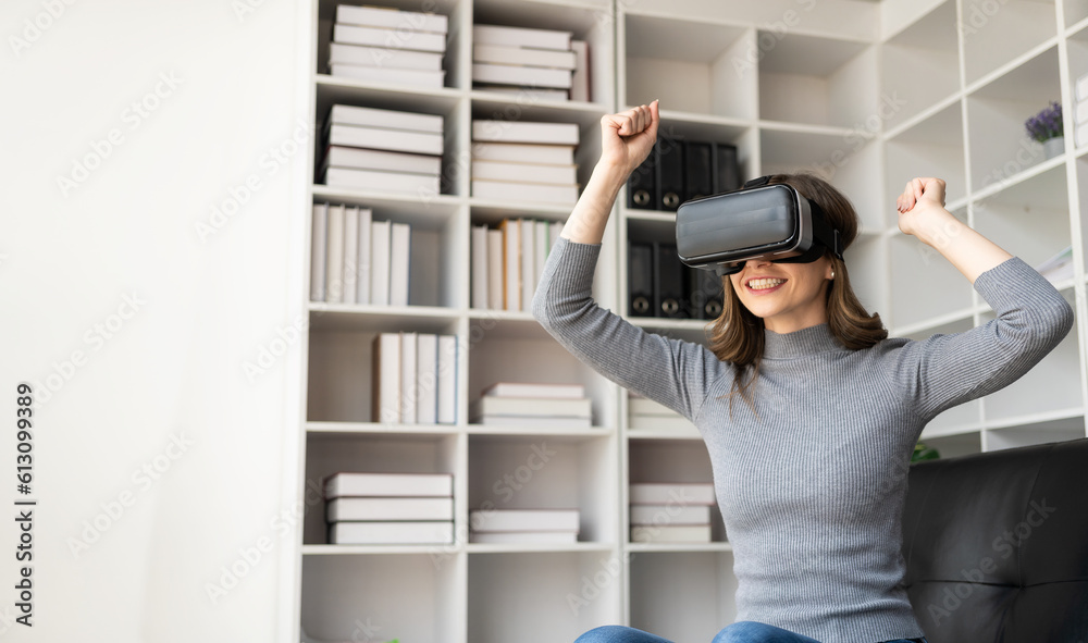 Surprised young latin woman in VR headset touching the air. Smiling caucasian woman wearing vr glasses virtual reality technology device watching 3d simulation video while sitting on sofa. Surprised young latin woman in VR headset touching the air. Smiling caucasian woman wearing vr glasses virtual reality technology device watching 3d simulation video while sitting on sofa.