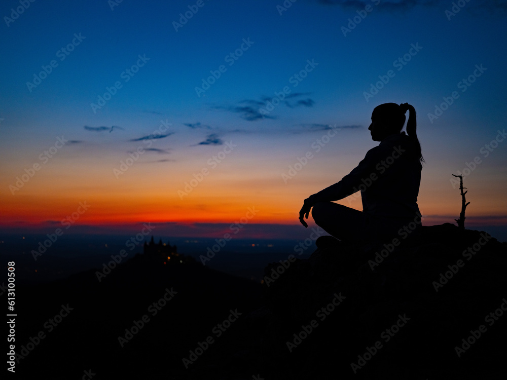 a girl in a lotus position sits on top of a mountain against the backdrop of sunset a girl in a lotus position sits on top of a mountain against the backdrop of sunset
