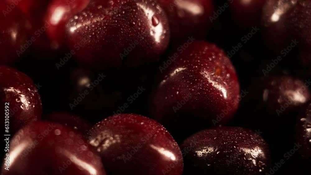 Red ripe cherries covered with water droplets, spinning on a black background. Wet sweet cherries rotate on a black plane Red ripe cherries covered with water droplets, spinning on a black background. Wet sweet cherries rotate on a black plane