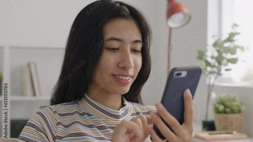 Asian happy smile girl using smartphone at home morning, Close-up young face Asian happy smile girl using smartphone at home morning, Close-up young face