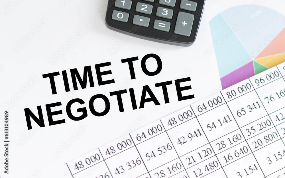 TIME TO NEGOTIATE text on a notebook with chart and keyboard TIME TO NEGOTIATE text on a notebook with chart and keyboard