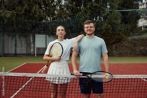 Happy Couple, tennis and sport portrait, training and exercise together outdoor, posing at tennis net on court.