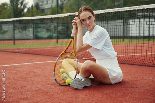 A Woman resting after play tennis on carpet court outdoors. Weekend and Sunday activity for recreation. Sports active game with friends. Tennis player in action. Tennis match. Active leisure game. © Davidovici