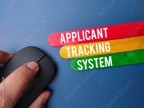 Wireless mouse and wooden stick with the word APPLICANT TRACKING SYSTEM photo