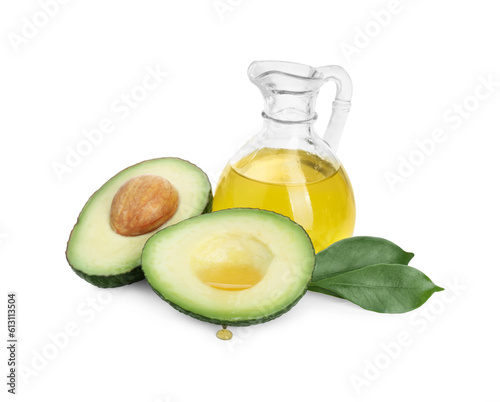 Jug of oil and cut avocado on white background
