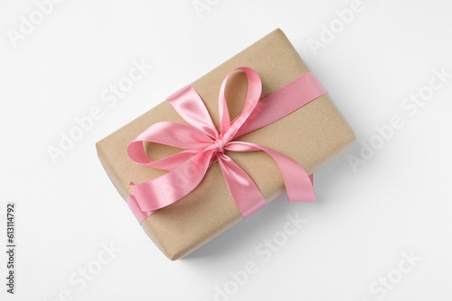 Beautiful gift box with pink bow on white background, top view