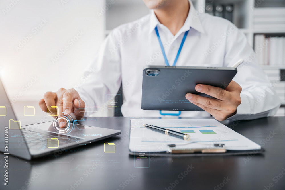 Businessman working on tablet and laptop computer with digital document, managing files data, paperless workflow, data search, cloud technology. Businessman working on tablet and laptop computer with digital document, managing files data, paperless workflow, data search, cloud technology.