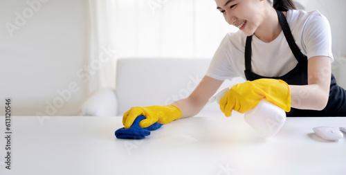 Asian beautiful young woman makes cleaning with a spray feel happy