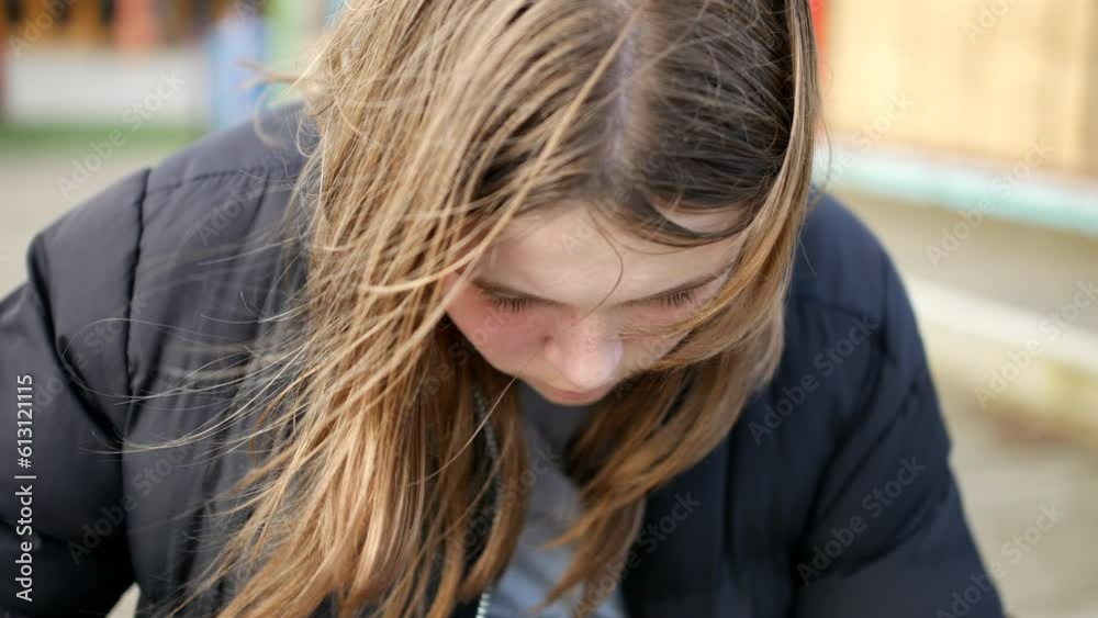 A depressed teenage girl sitting alone on a cold day A depressed teenage girl sitting alone on a cold day
