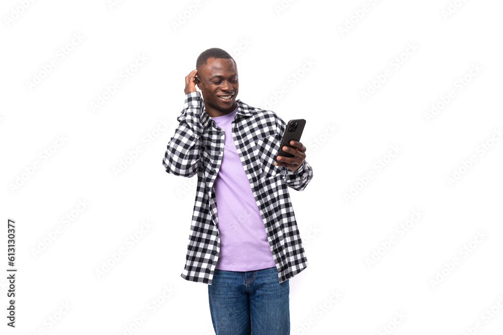 handsome young american man in plaid shirt chatting on smartphone handsome young american man in plaid shirt chatting on smartphone