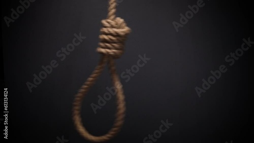 Rope noose with hangman knot on dark background, death penalty concept