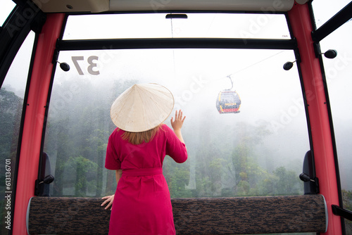 Woman tourist is sitting on  the Cable car while traveling to Ba Na Hills at da nang, Vietnam. photo