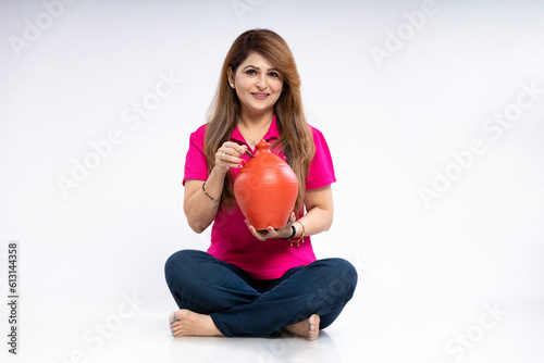 Indian woman giving expression with clay piggy bank