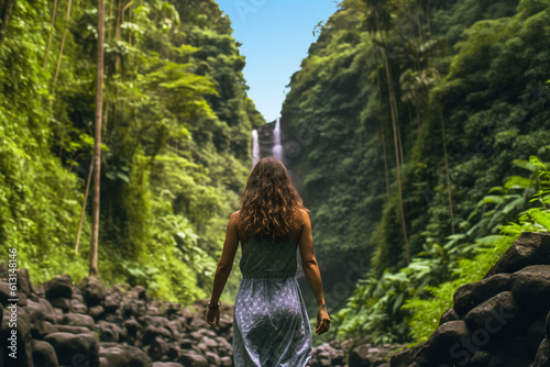 Photo of the back of a woman in summer clothes running toward tropical forests and waterfalls. AI generative