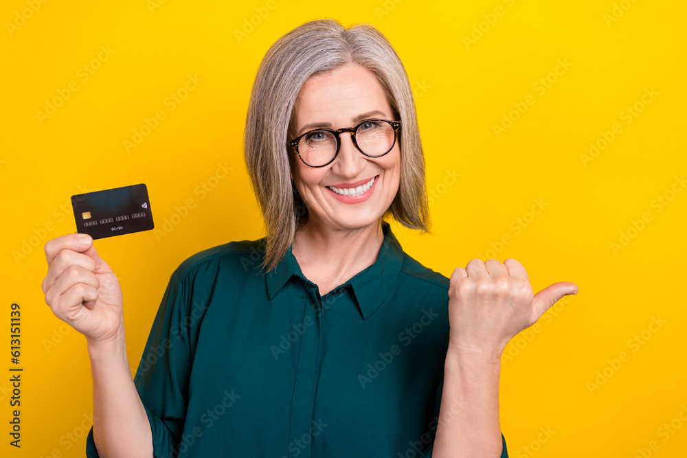 Photo of trader lady pointing empty space finger recommend easy banking with deposit card isolated shine color background Photo of trader lady pointing empty space finger recommend easy banking with deposit card isolated shine color background