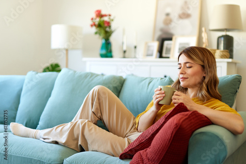 An attractive young woman relaxing at home drinking coffee