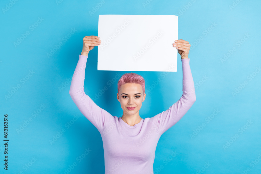 Photo of satisfied person with short haircut wear stylish sweatshirt arms holding placard over head isolated on blue color background Photo of satisfied person with short haircut wear stylish sweatshirt arms holding placard over head isolated on blue color background