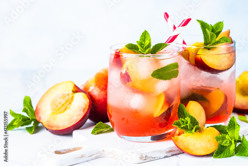 Peach peach tea, iced fruit drink, summer beverage with fresh fruits and mint. Close up with space for text.