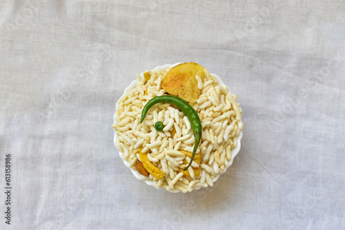 Top view of Murmura spicy puffed rice, Jhal Muri, Borugulu and green chilli, in Kolkata, West Bengal, India. is a traditional home made Vegan mid-morning snack or cereal breakfast, Indian street food.