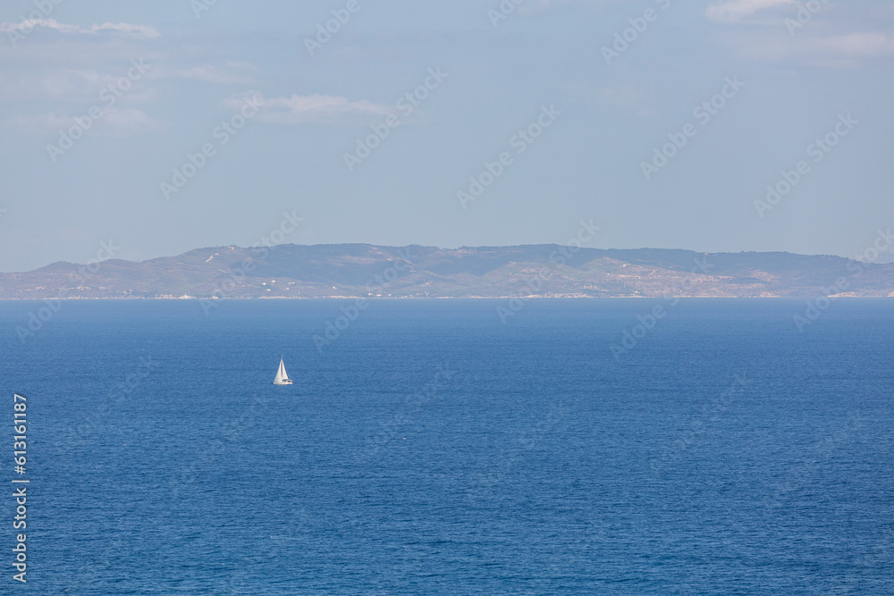 A serene Greek island scene: blue sky, sea, and horizon