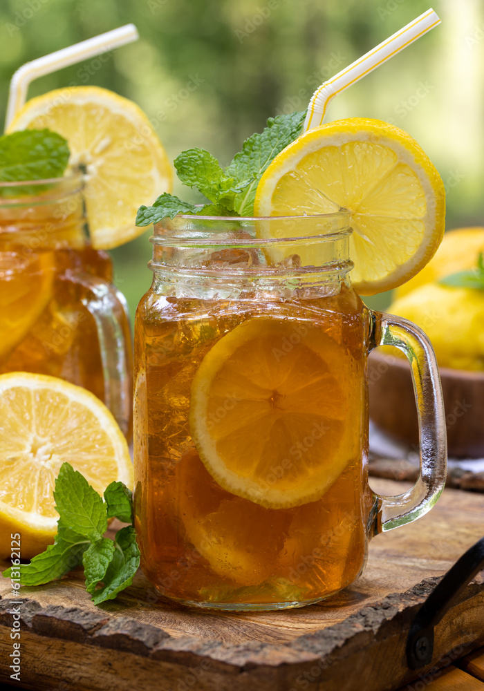 Ice tea in two glass jars with lemon and mint Ice tea in two glass jars with lemon and mint