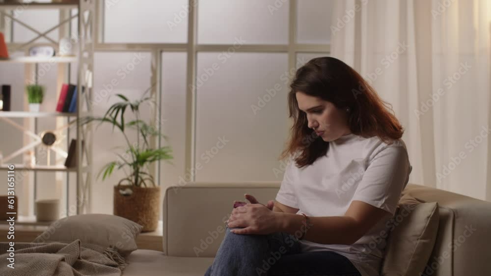 Young brunette girl sitting focused on the phone. A cozy room, a young girl is actively using her phone. Young brunette girl sitting focused on the phone. A cozy room, a young girl is actively using her phone.