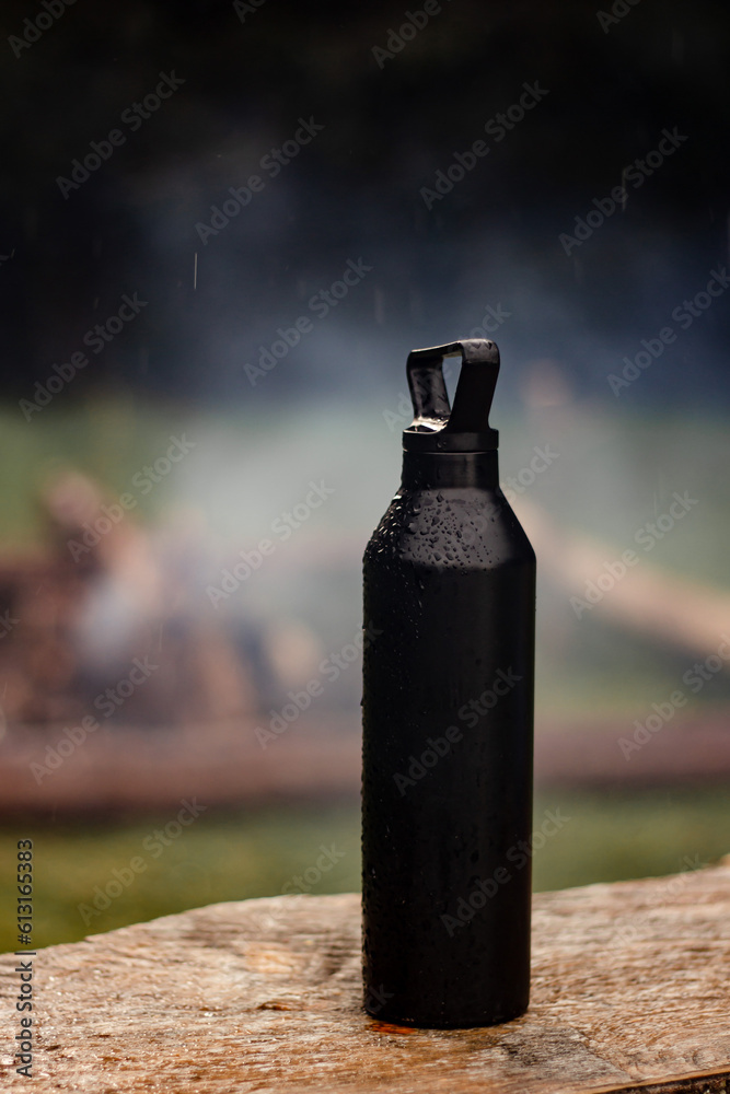 Steel eco-friendly thermal bottle against the backdrop of a campfire in the mountains. Camping without plastic and waste. Be plastic-free. Zero waste. Copy space. Zero waste, no plastic. Steel eco-friendly thermal bottle against the backdrop of a campfire in the mountains. Camping without plastic and waste. Be plastic-free. Zero waste. Copy space. Zero waste, no plastic.