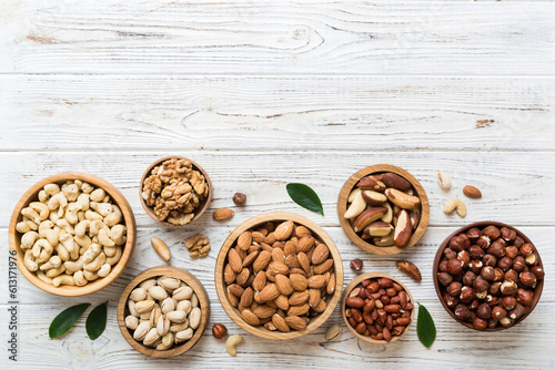 mixed nuts in wooden bowl. Mix of various nuts on colored background. pistachios, cashews, walnuts, hazelnuts, peanuts and brazil nuts
