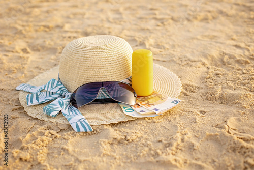 Vacation time - straw hat, sunglasses, suncream and money, ready for a holiday