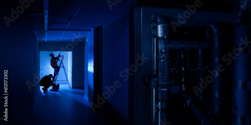 Workers in dark corridor. R...